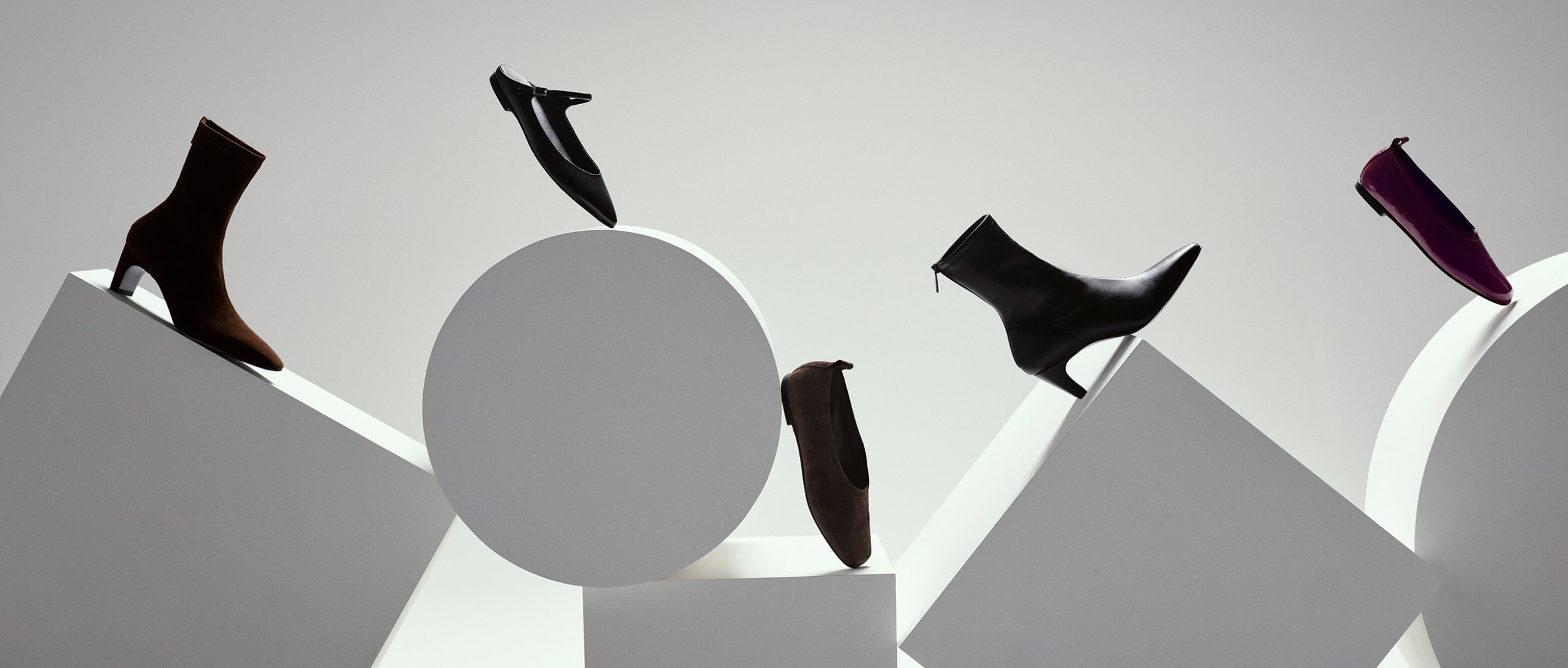 Whistles x ESSEN collaboration showcasing modern women’s boots and flats in minimalist sculptural display. sustainable luxury footwear collection.