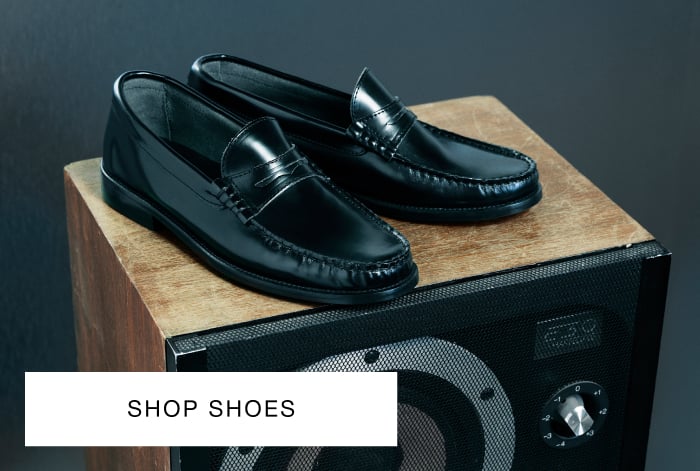 Whistles' burgundy slim leather loafer with a rounded toe, low heel and penny strap detail, placed on a dark wooden block