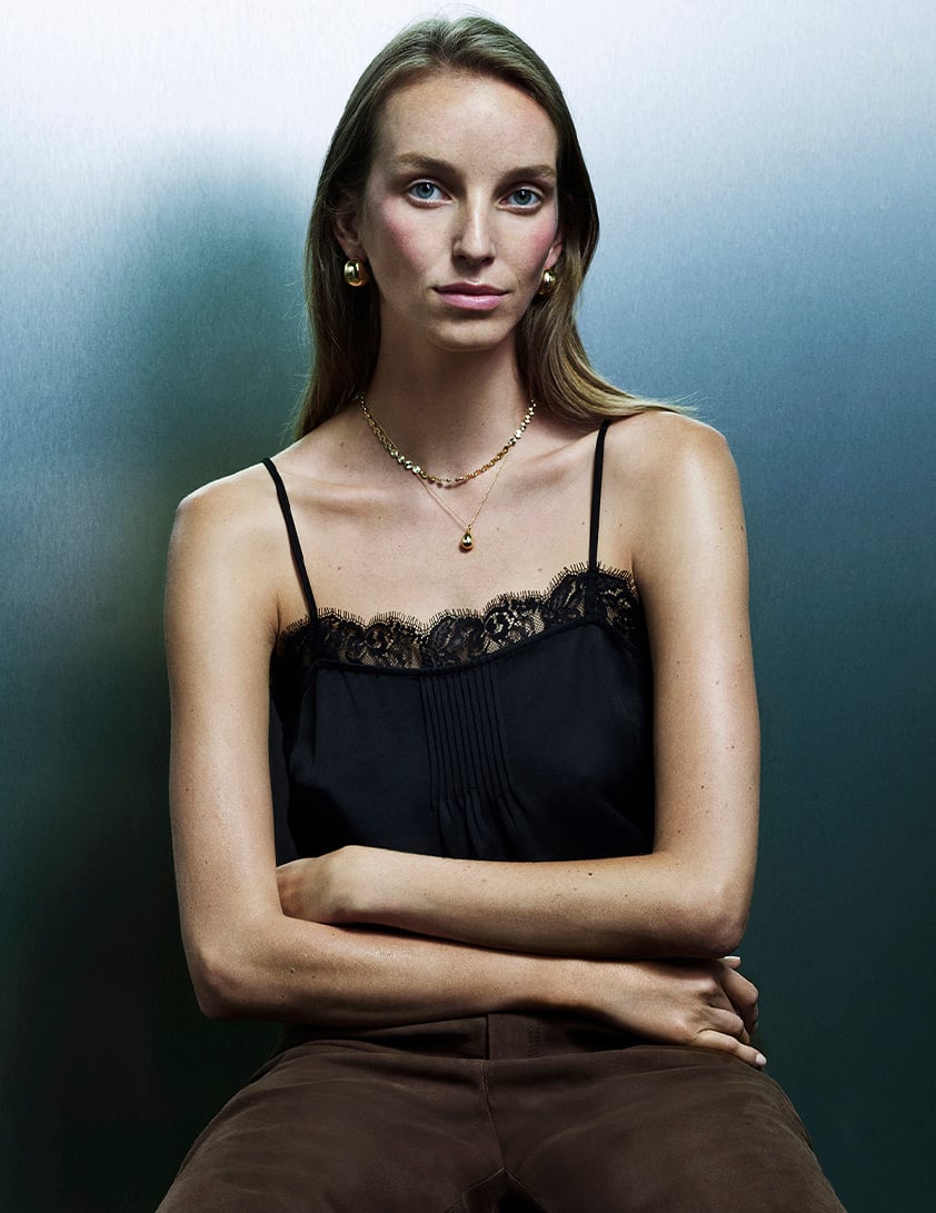 Woman wearing a Whistles black strappy cami top with lace detailing