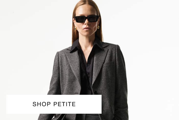 woman wearing Whistles grey herringbone wool blazer and black oversized shirt with sunglasses
