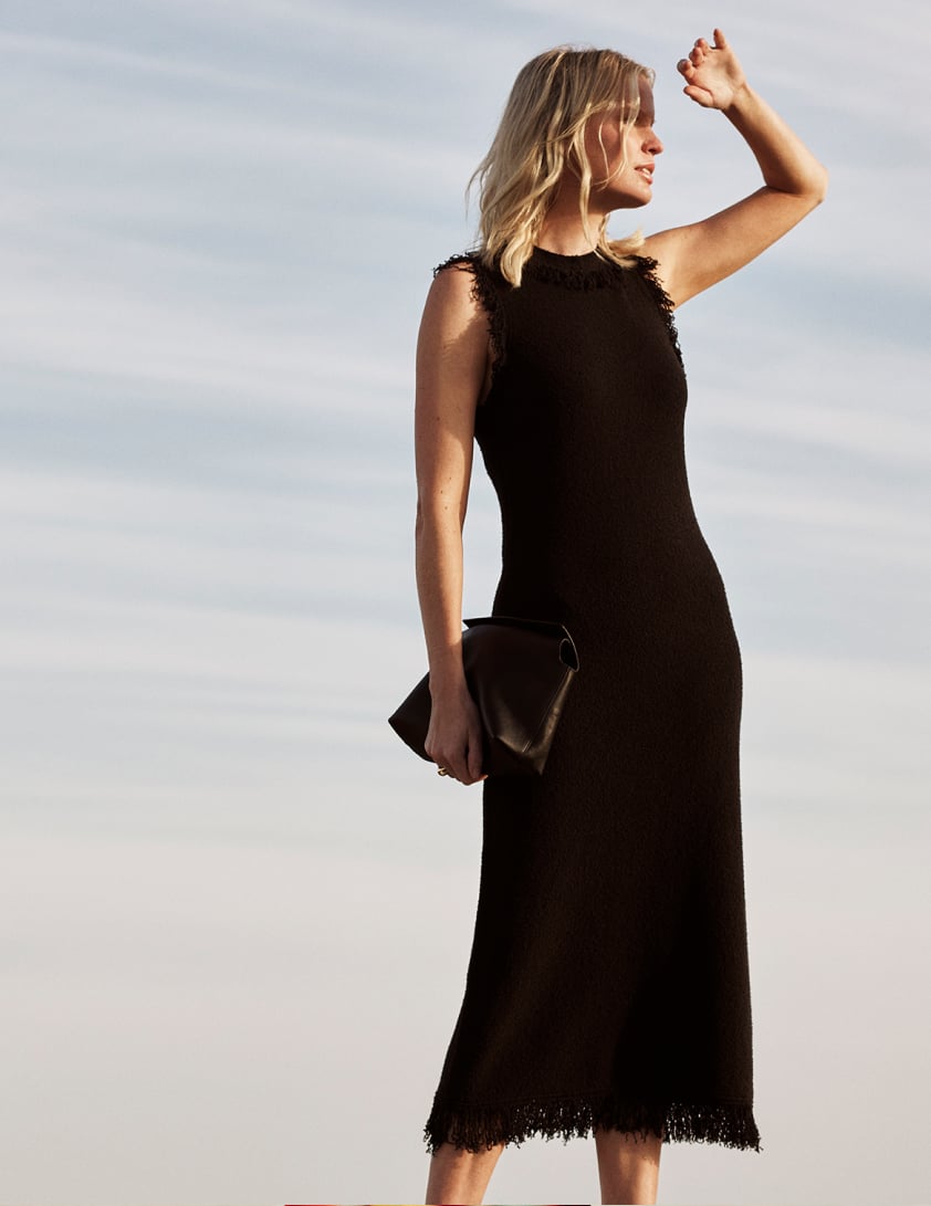 Woman wearing black dress with fringe detail 