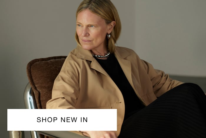 Woman wearing Whistles short cotton trench jacket in beige with belted waist and button fastening