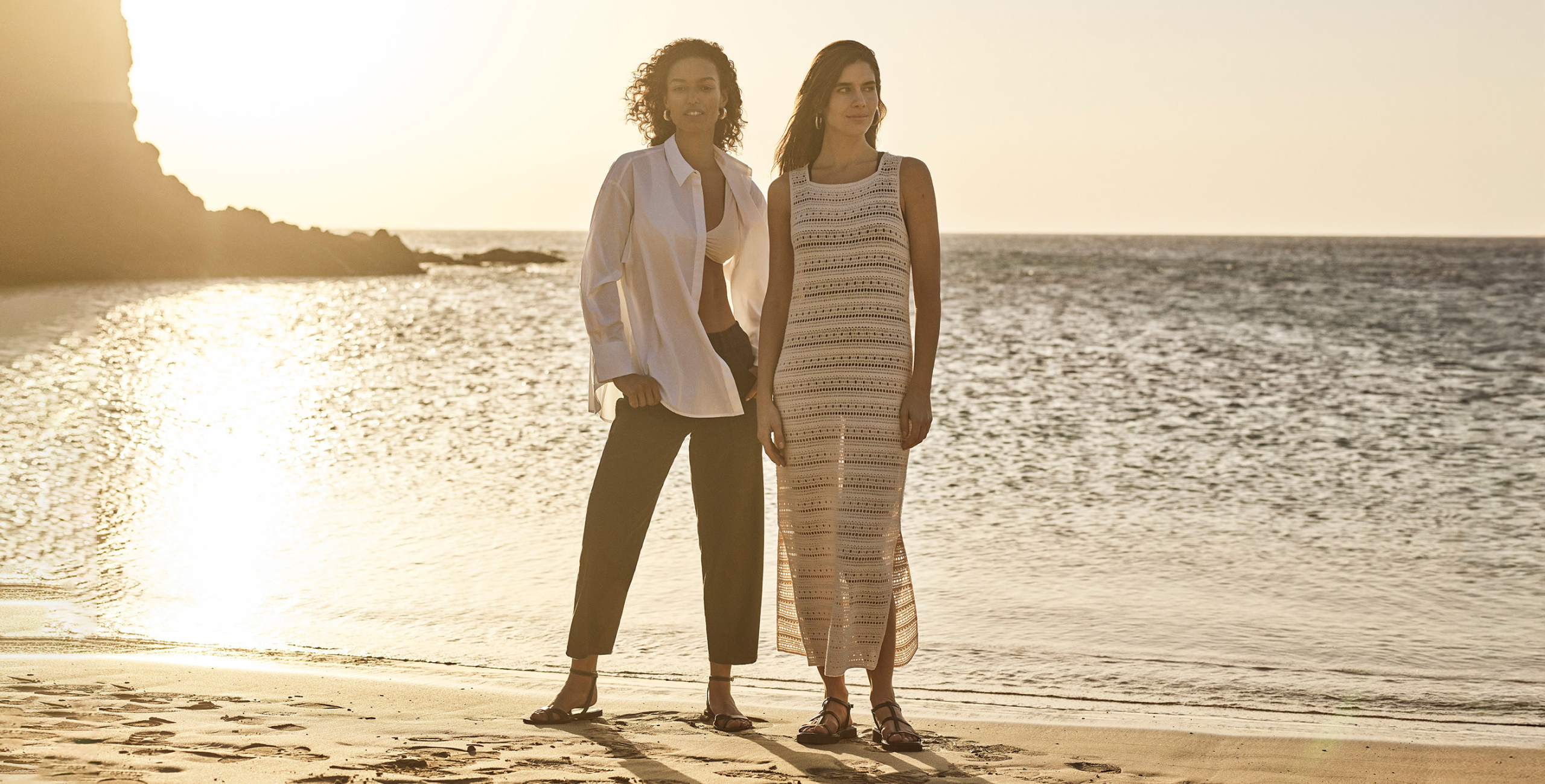 2 woman wear linen shirt and trousers and a cream dress