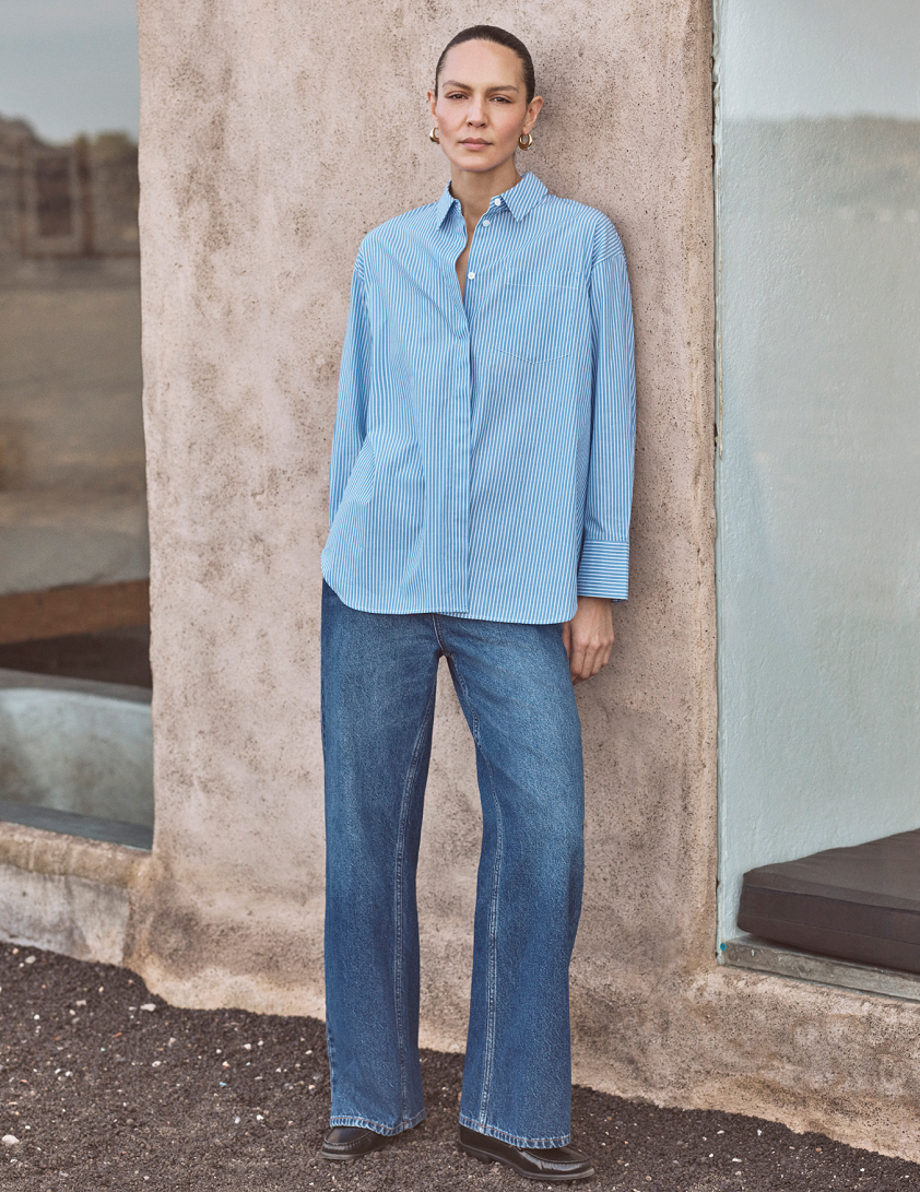 woman waerring dark denim jeans and a grey coat